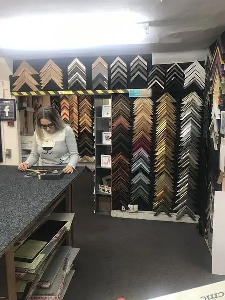Choosing frame mouldings at the counter in Tripps of Keynsham framing workshop