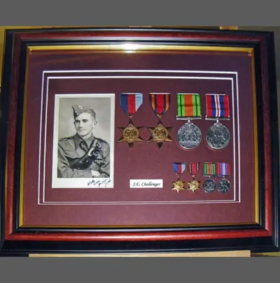 Second World War medals and portrait photograph on a burgundy mount framed by Tripps of Keynsham