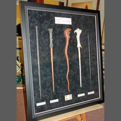 Wooden wands in a dark box frame framed by Tripps of Keynsham