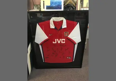 Signed red football shirt in a black box frame framed by Tripps of Keynsham
